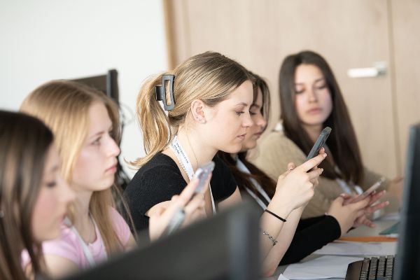 Schülerinnen arbeiten im Medienseminar mit dem eigenen Handy