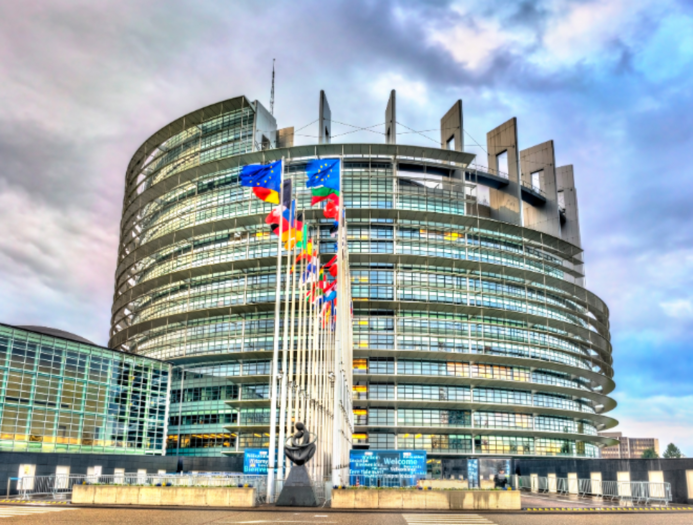 EU Parlament Straßburg mit Fahnen davor.