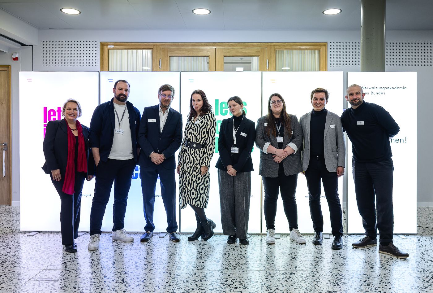 Die Veranstalter des Events CommunityConnect stehen vor leuchtenden Schildern