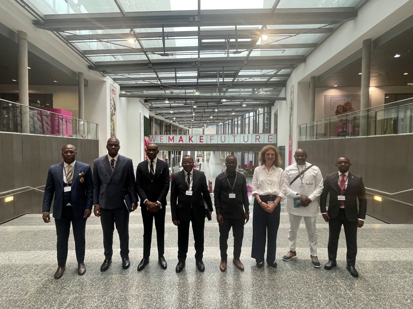 Eine Delegation aus Kamerun steht mit der Leitung der Verwaltungsakademie im Foyer des T-Center