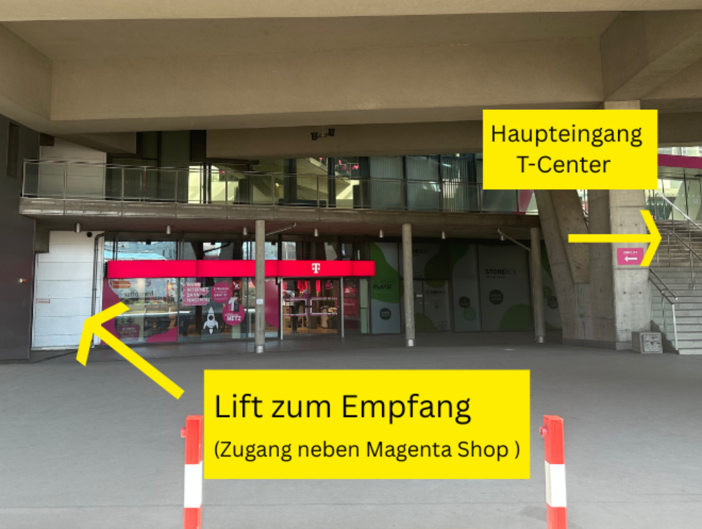Linker gelber Pfeil zeigt den Weg zum Lift zum Empfang im T-Center. Rechter gelber Pfeil zeigt auf die Treppe zum Haupteingang.