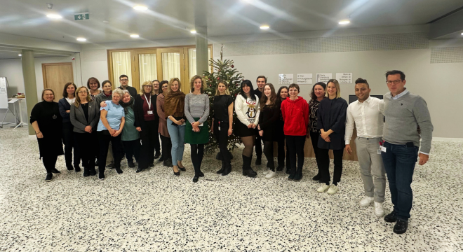 Das Team der Verwaltungsakademie im Foyer des Standorts T-Center vor einem Christbaum